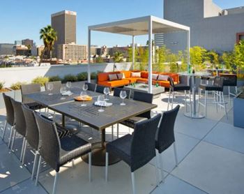 a terrace with a table and chairs and a city in the background